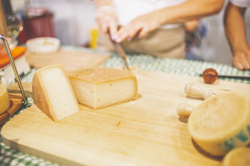 Different types of cheese on stand at food festival.