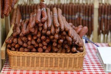 Sausage exhibition and fair. Smoked thin sausages in a basket