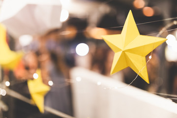 Paper stars at christmas market background abstract.