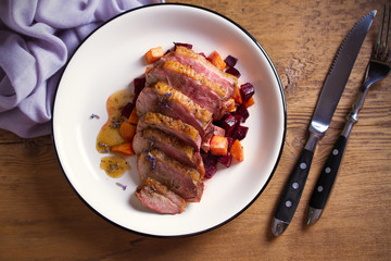 Sliced duck breast fillet with sweet potatoes and  beetroot on plate