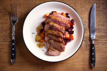Sliced duck breast fillet with sweet potatoes and  beetroot on plate
