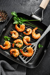 Grilled shrimps on pan on dark background