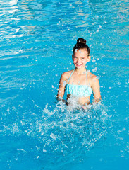 Cute smiling little girl child having fun in the swimming pool