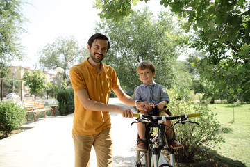 Bicycle ride of father and his son on baby seat