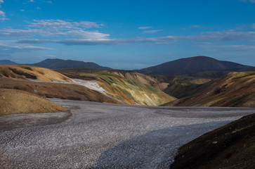 Fototapeta na wymiar Colorful Rhyolit mountain panorma with snow fiields and multicolored volcanos in Landmannalaugar area of Fjallabak Nature Reserve in Highlands region of Iceland
