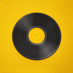 Vinyl record on a colored background. Old vintage vinyl record isolated on yellow background
