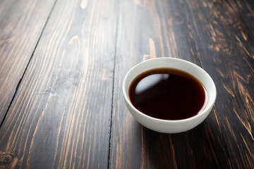 Soy sauce and soy bean on wooden table.