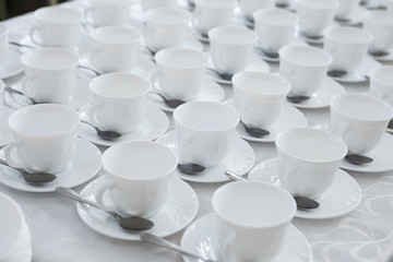 empty white coffee tea cups in rows on the table