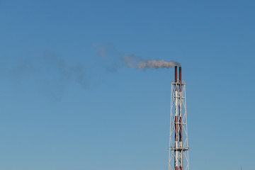 Smokestack billowing from a small plant