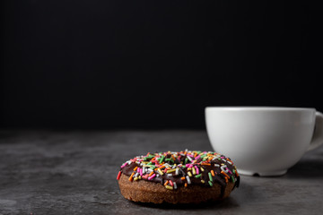  Donuts with chocolate glaze with sprinkles on wooden table.