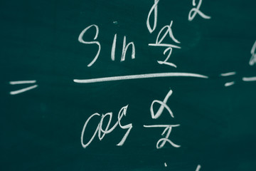 Fototapeta na wymiar Trigonometric equation written on the chalkboard. School curriculum.