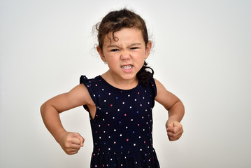 Angry and aggressive young girl with clenched teeth and fists looking at the camera
