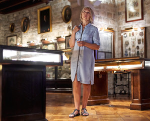 Woman visitor in museum looking at art object.