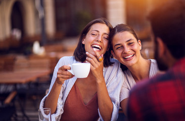 Smiling friends drinking coffee and laughing