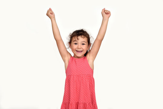 Happy and smiling cute young girl with hands up looking at the camera