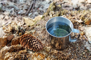 Obraz premium metal cup of water on a stump in the forest