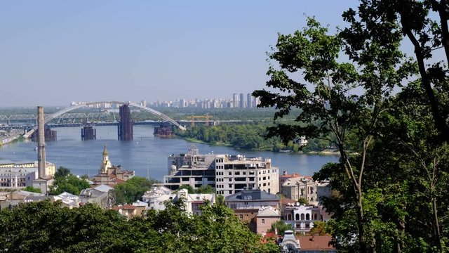 Panoramic video picture cityscape top view of the embankment from the right bank of the Dnieper in Kiev, Ukraine, 08/19/2019 district of the river station, Podil and the bridge under construction, hig