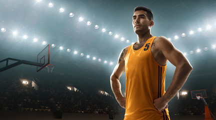 Fototapeta na wymiar Professional basketball player in sports uniform on basketball court with a ball