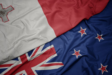 waving colorful flag of new zealand and national flag of malta.