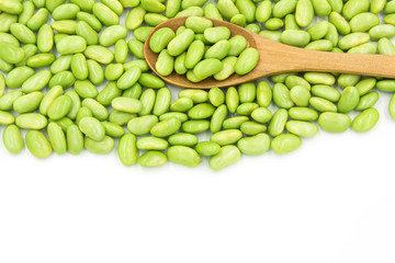 Dense green soybeans and wooden spoon top view