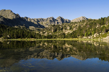 Naklejka na ściany i meble Reflections in a high mountain lake.