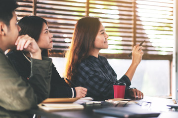 Businesspeople looking and discussing ideas over a board in office