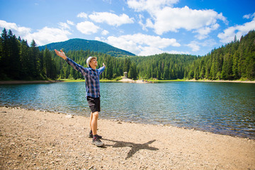 Free man with open arms near mountains lake. success. Travel and Freedom concept. Good life.