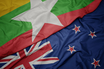 waving colorful flag of new zealand and national flag of myanmar.