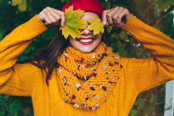 Autumn woman in autumn park. Warm sunny weather. Fall concept.Pretty girl in a beret and a sweater in autumn park