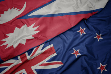 waving colorful flag of new zealand and national flag of nepal.