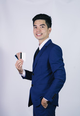 Portrait handsome young asian man wearing a blue shirt holding credit card and smile isolated on white background. Asian man people. business success concept.