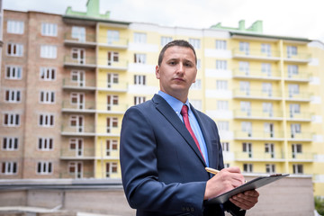 Broker with key from new apartment near new house