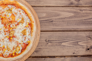 Hawaiian pizza on dark rustic wooden background. Top view, copy space