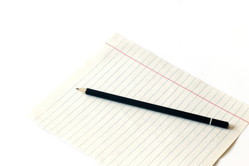 Pencil on a piece of paper on a white background. Pencil and notebook. Close-up. Copy space