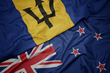 waving colorful flag of new zealand and national flag of barbados.