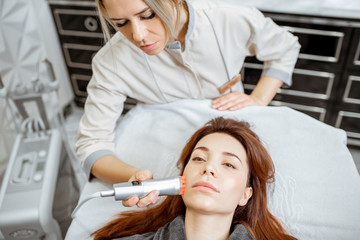 Female cosmetologist making oxygen mesotherapy to a woman at the luxury beauty salon. Concept of a...