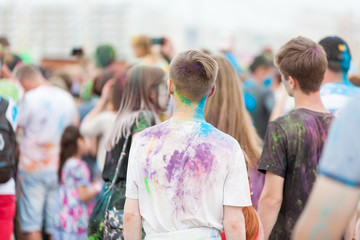 a copy space with people shot from the back side with their colorful clothes stained with holi colors on Holi Festival, Festival of Colors
