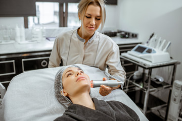 Female cosmetologist making oxygen mesotherapy to a woman at the luxury beauty salon. Concept of a...