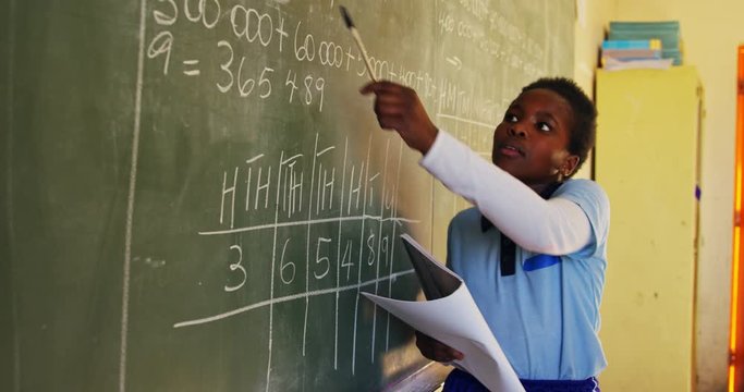 Young schoolgirl standing at the blackboard in class 4k