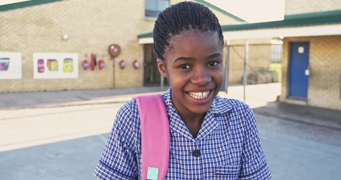 Portrait of a young schoolgirl smiling in playground 4k