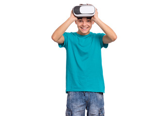 Happy teen boy wearing virtual reality goggles watching movies or playing video games. Cheerful smiling teenager looking in VR glasses. Funny child experiencing 3D gadget technology.