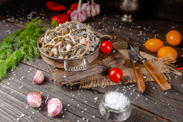 seaweed and carrot salad, mayonnaise sauce, in a rustic rustic bowl bowl, fork knife spoon, spices,...