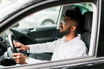 Indian bearded businessman driving car on the road