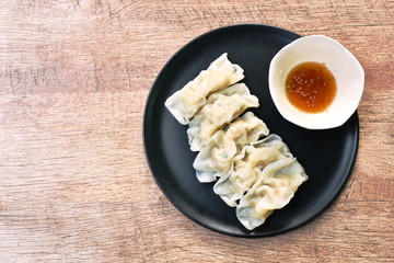 steamed Gyoza or Japanese dumpling stuffed minced pork dipping shoyu sauce on plate