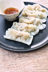 steamed Gyoza or Japanese dumpling stuffed minced pork dipping shoyu sauce on plate