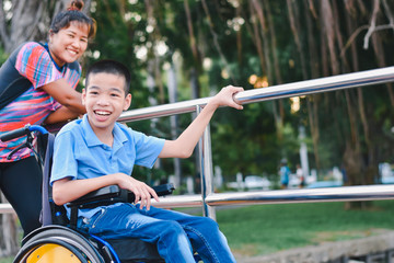 Disabled child on wheelchair is play and learn in the outdoor park like other people, He has adult care and love, Life in the education age of special children, Happy disability kid concept.
