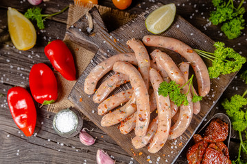 homemade hotdog sausages, raw from red and white fish meat, in a vintage rustic bowl plate, fork...