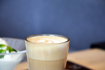  Aromatic coffee with a pattern in a glass cup on a brick wall background.
