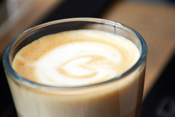  Aromatic coffee with a pattern in a glass cup on a brick wall background.