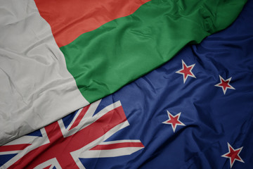 waving colorful flag of new zealand and national flag of madagascar.